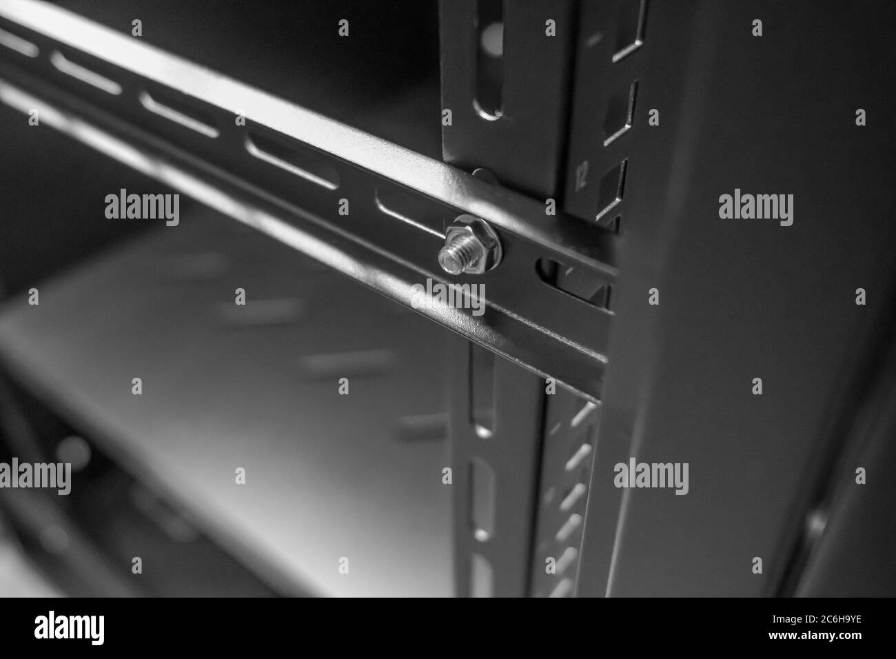 Imagen detallada de un equipo y un gabinete de servidor de red que muestra  los postes internos de 19 pulgadas de bastidor. Se ve en un centro de datos  para el alojamiento