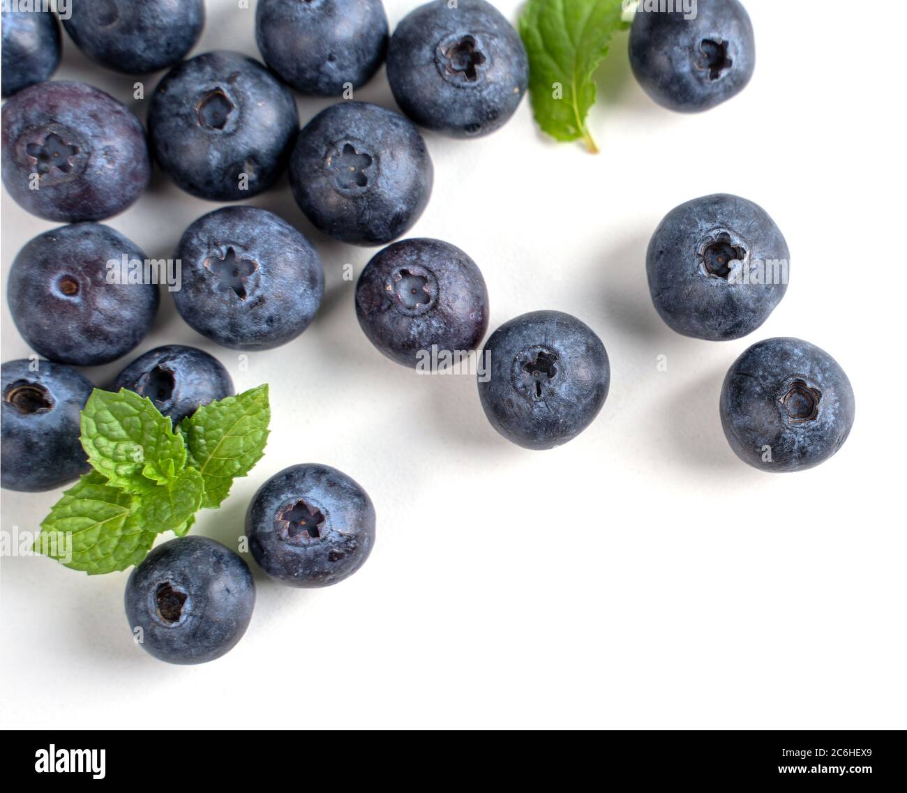 Vista superior de arándanos aislados sobre un fondo blanco, plano sobre disposición con hoja de menta, concepto de diseño saludable. Foto de stock