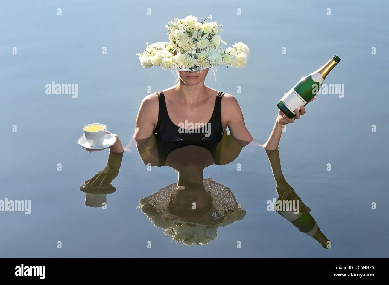 Mujer joven sirviendo una taza de café y champán Foto de stock