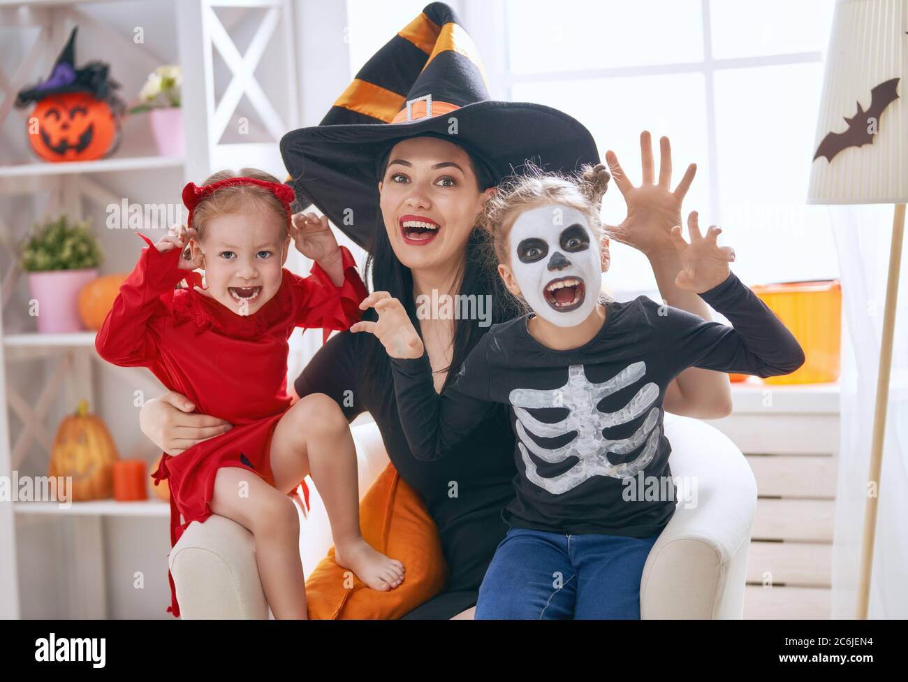 Feliz familia preparándose para Halloween! Mamá joven y sus hijos en  disfraces de carnaval celebrando las fiestas Fotografía de stock - Alamy