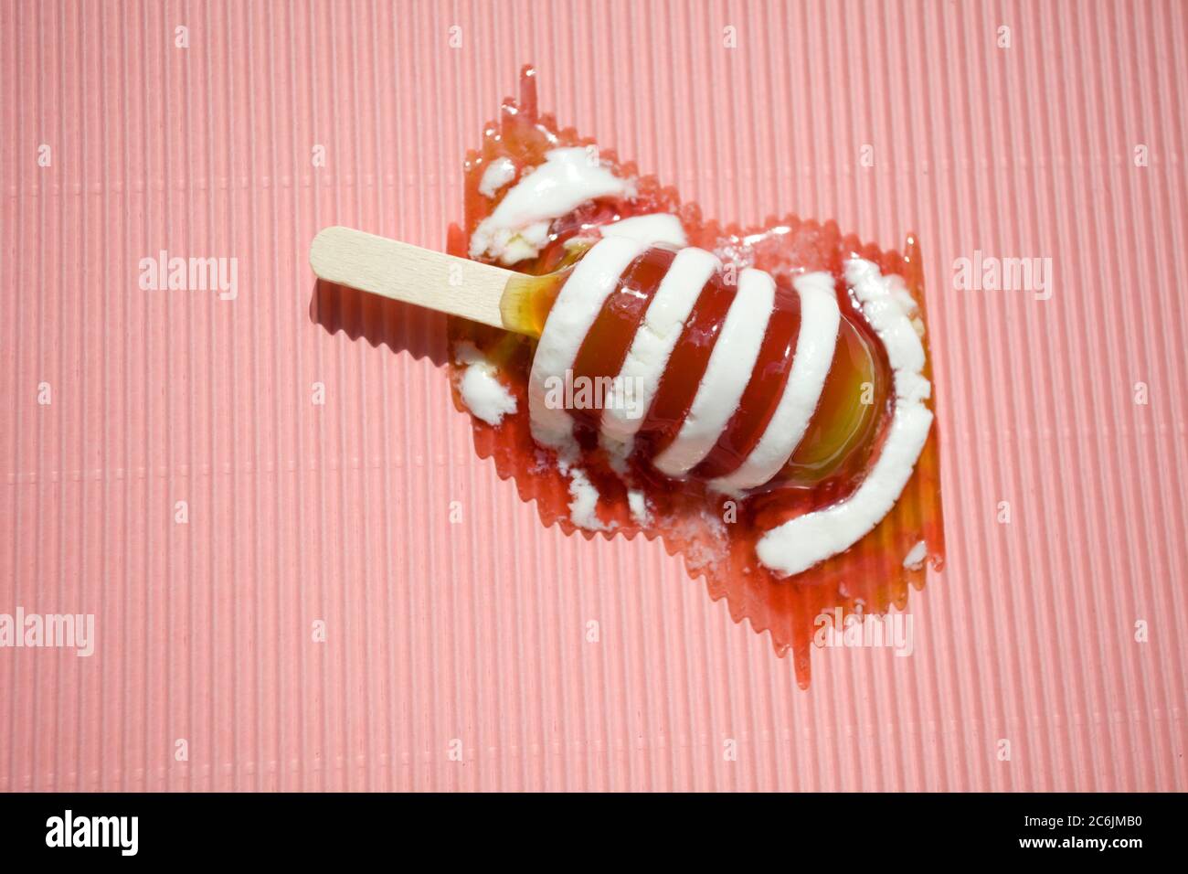 Twister derretido hielo lolly sobre fondo rosa Foto de stock