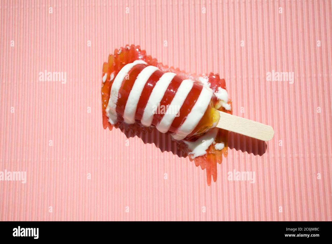 Derretir Twister hielo lolly sobre fondo rosa Foto de stock