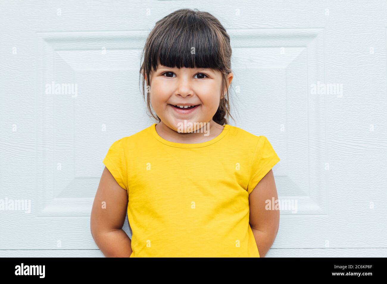 Adorable niño latino weraring una camiseta amarilla aislado sobre