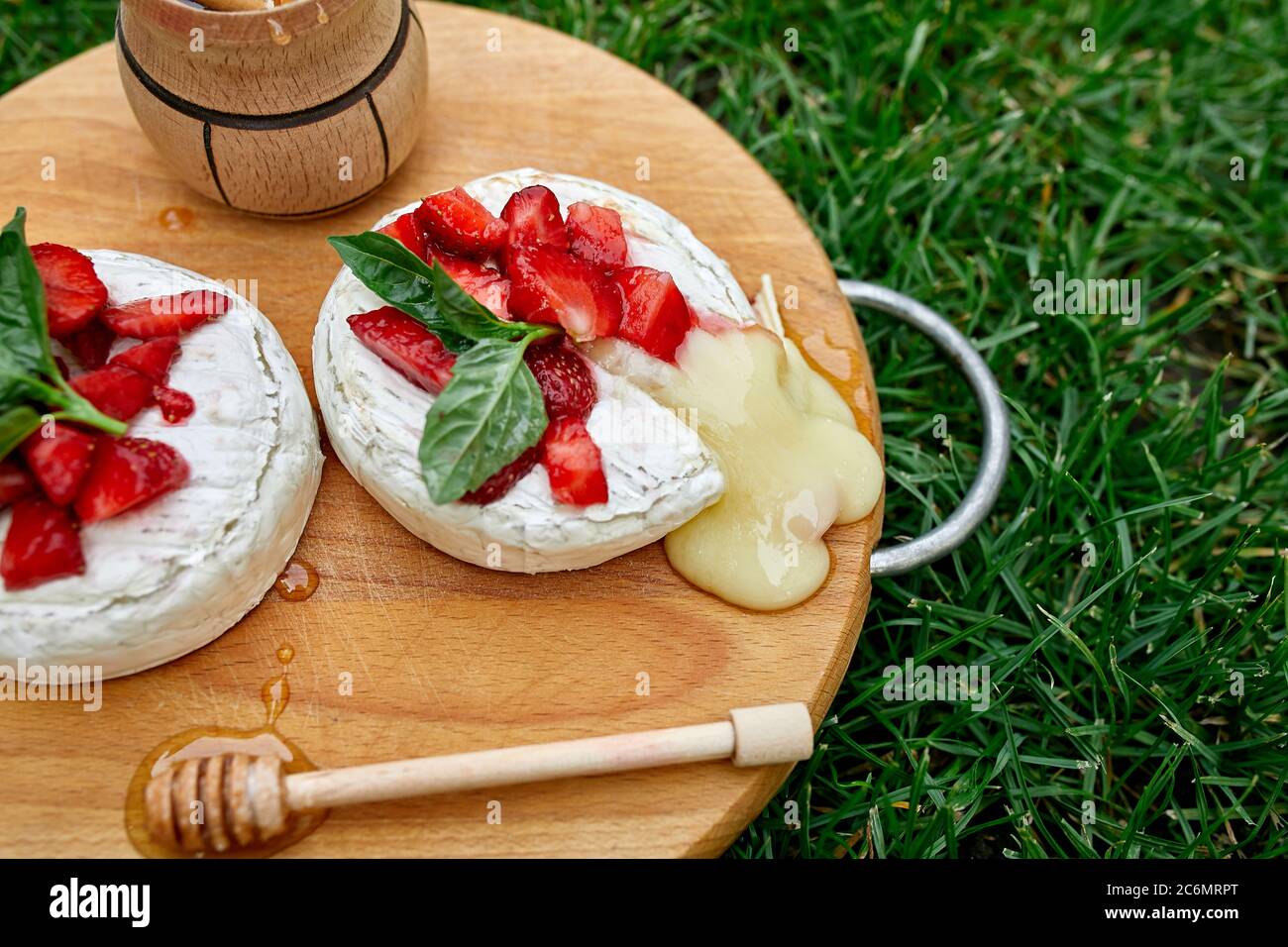 Queso camembert a la parrilla con hojas de fresa, miel y albahaca,  delicatessen, fondue de queso camembert sobre el fondo de la hierba  Fotografía de stock - Alamy