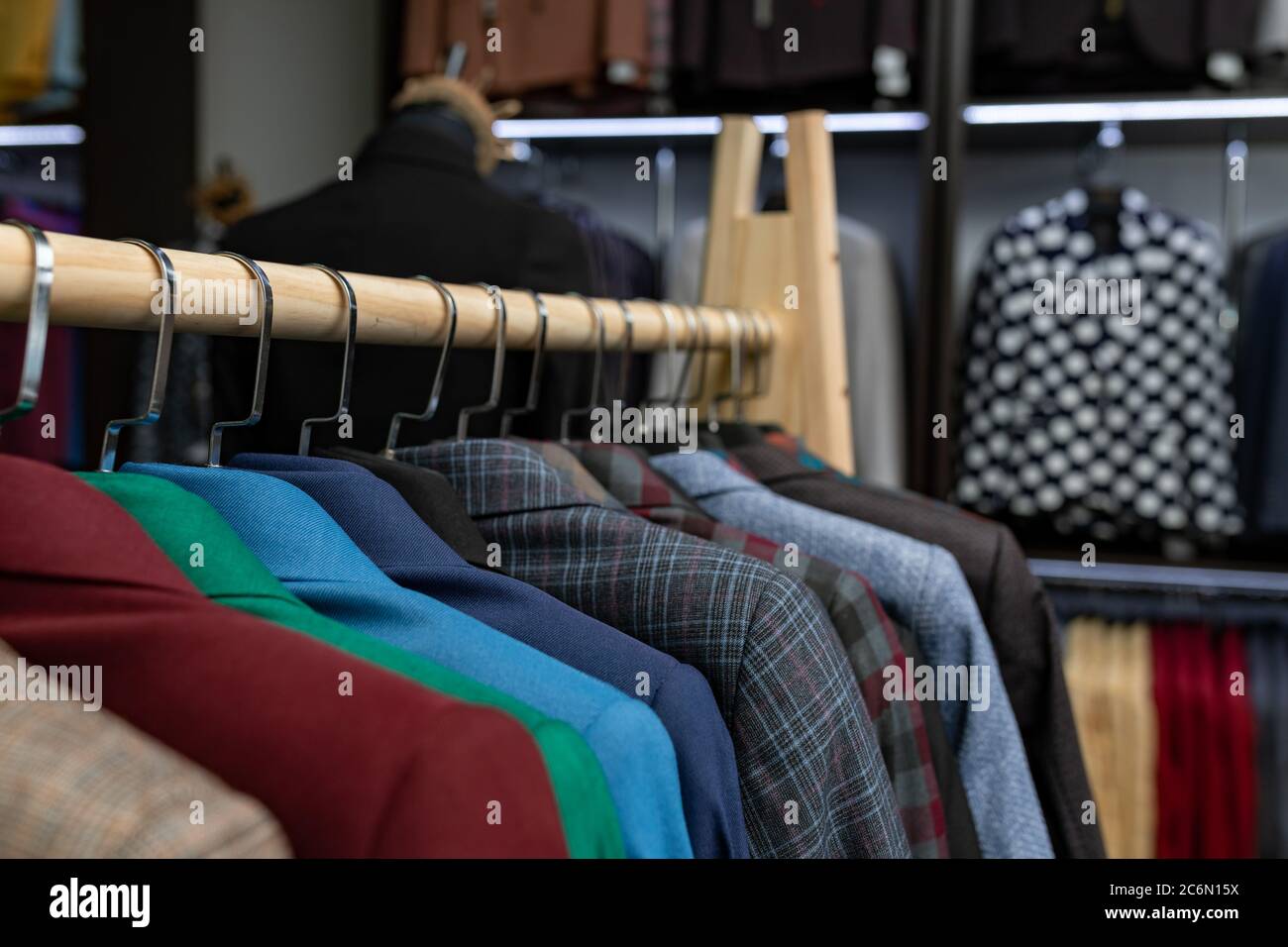 tienda de ropa hombre cara. una fila chaquetas en perchas. tema de fondo de venta de compras. ropa en percha en tienda Fotografía de stock - Alamy