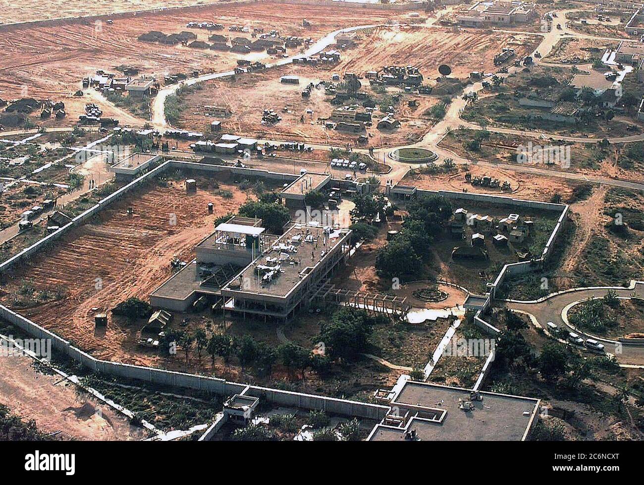 Vista aérea del lado izquierdo del recinto de la embajada estadounidense en Mogadiscio, Somalia. El cuartel general de la Fuerza de Tarea Conjunta para restaurar la esperanza está ubicado allí. Existen planes para construir una ciudad de carpas en el recinto. Varias tiendas de campaña y equipo de las Naciones Unidas están situados fuera de los muros de la embajada en la parte superior del bastidor. Esta misión está en apoyo directo de la operación Restaurar la esperanza. Foto de stock