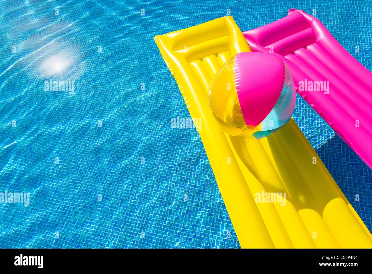 Cama inflable rosa y una colorida de playa para divertirse en la piscina Fotografía de stock - Alamy