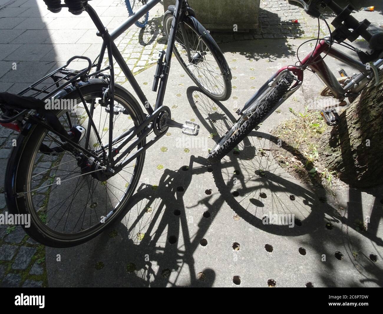 Ruedas de bicicleta y sus sombras en la pasarela de la ciudad Foto de stock