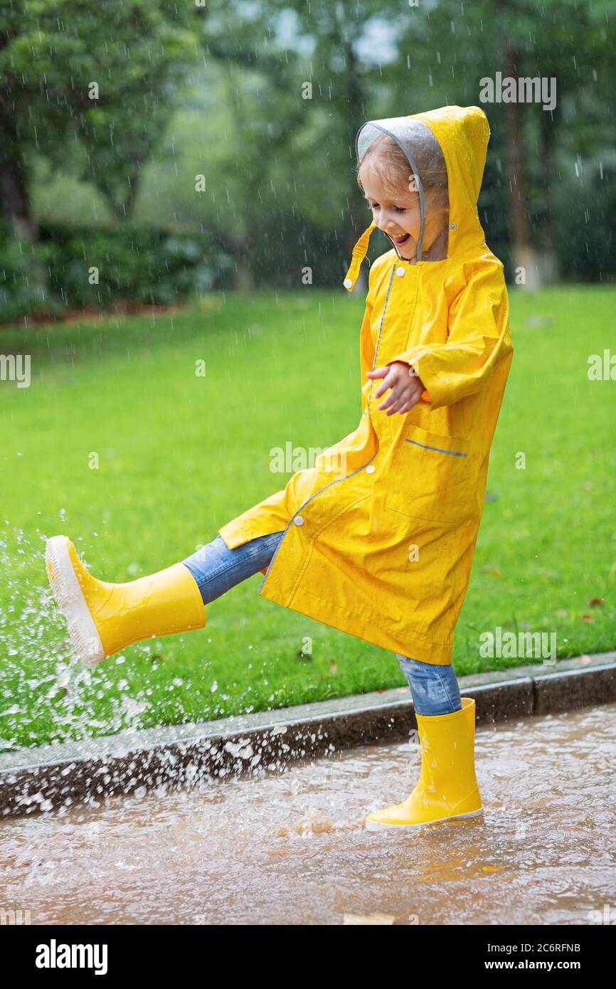 Niño Vestido Con Capa Impermeable Amarilla Y Botas De Goma Parado En Un  Charco Al Aire Libre En La Lluvia En Otoño Imagen de archivo - Imagen de  libertad, lluvia: 198114641