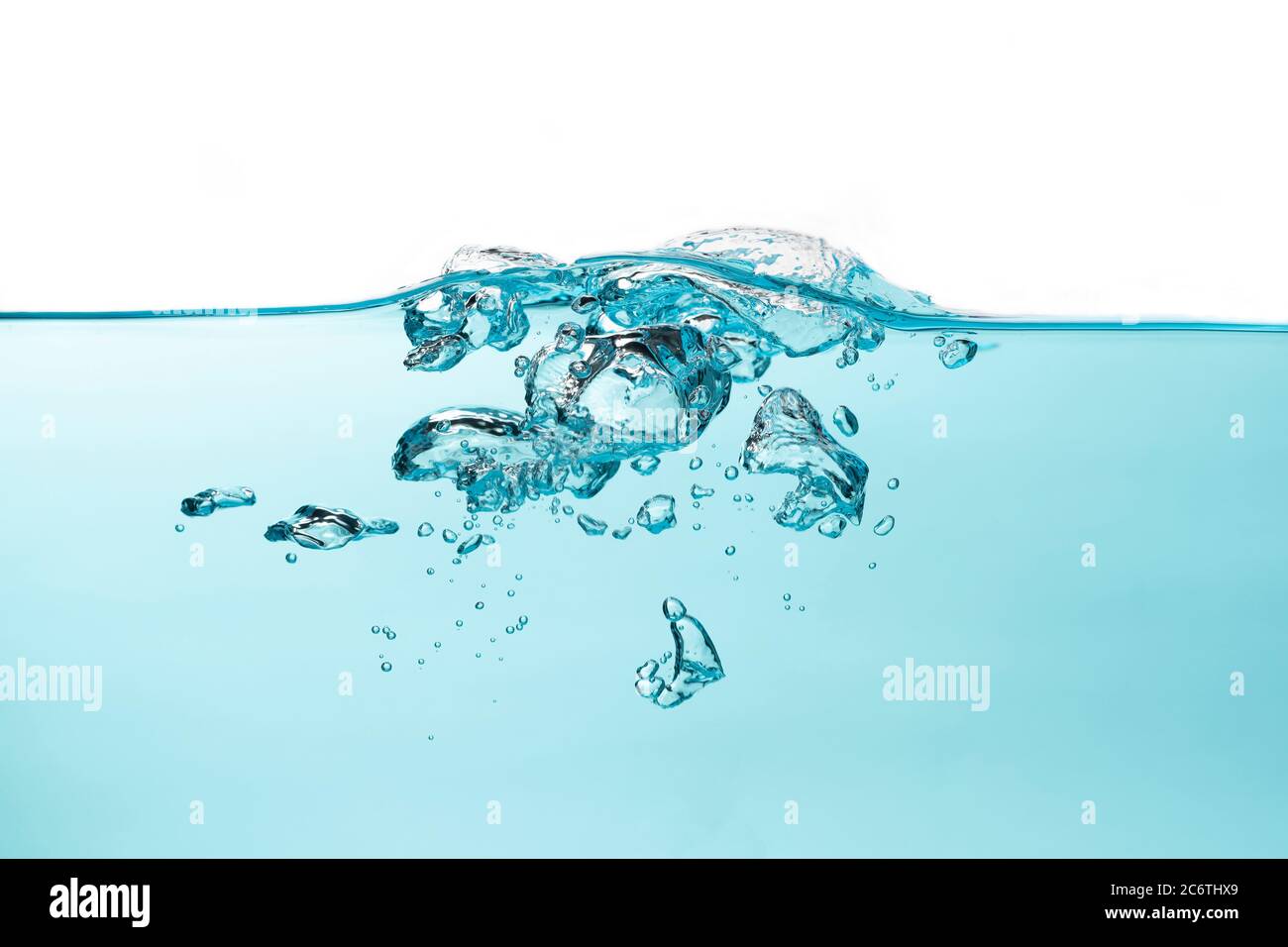 Burbujas de aire y salpicaduras de agua, salpicaduras de agua aisladas sobre fondo blanco y azul. Foto de stock