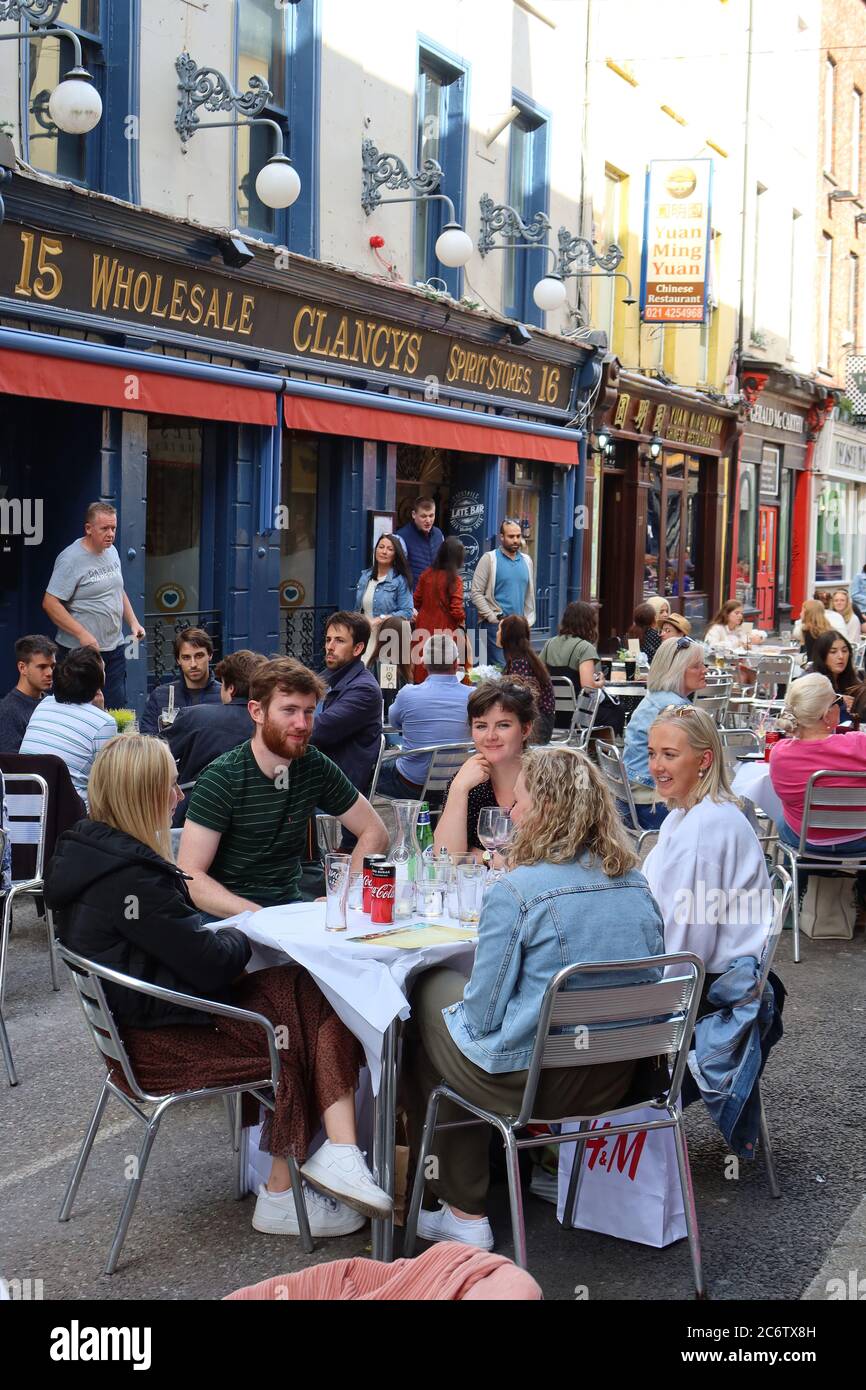 Gente, relajándose y disfrutando de la comida, afuera, en restaurantes al aire libre en Princes Street, Cork, Irlanda Foto de stock