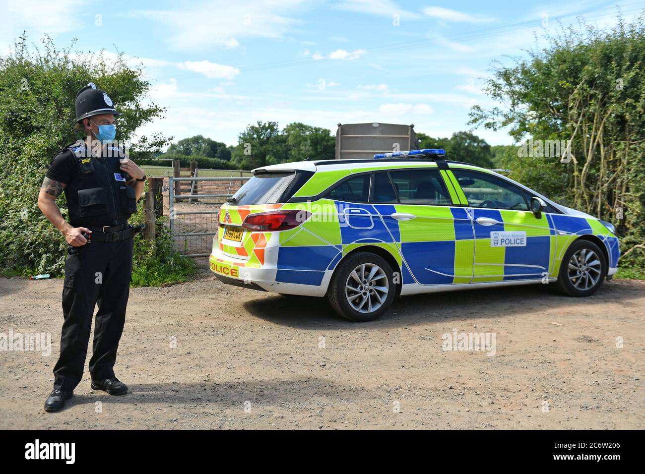 Un agente de policía que llevaba una máscara en Rook Row Farm en Mathon, cerca de Malvern, Herefordshire, donde se han confirmado 73 casos positivos de coronavirus. Foto de stock