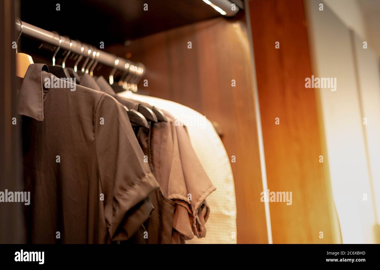 La camisa de tonos tierra colgando en el armario marrón moderno para el  nuevo diseño interior con el concepto de armario empotrado y de la walkin  Fotografía de stock - Alamy