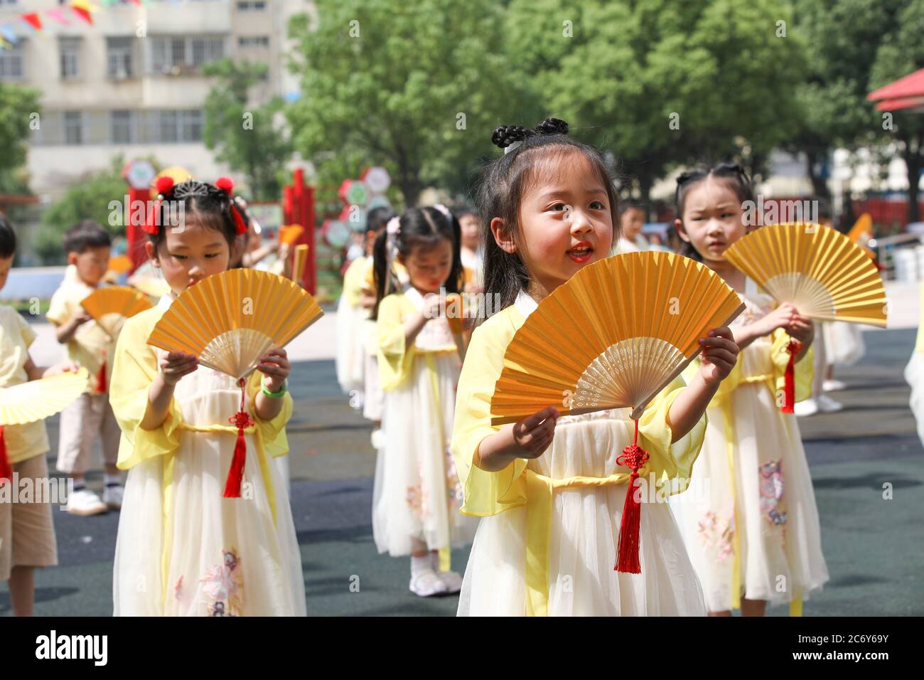 Vestidos con ropa China antigua, los niños en un baile de jardín de  infantes local y hacer la bolsa de medicina tradicional perfumada para  celebrar el próximo Dragón Fotografía de stock -