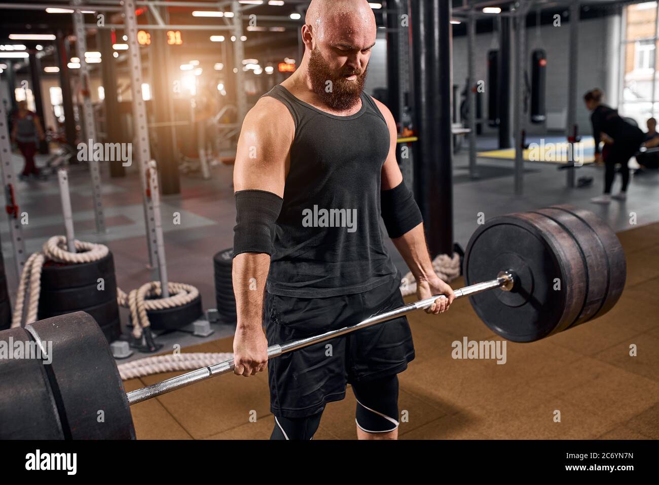 Entrenamiento en el gimnasio. Deportes Hombre un lifting con barra pesada, mirando con cara fuerte, aderezos en elegante ropa deportiva Fotografía de stock - Alamy