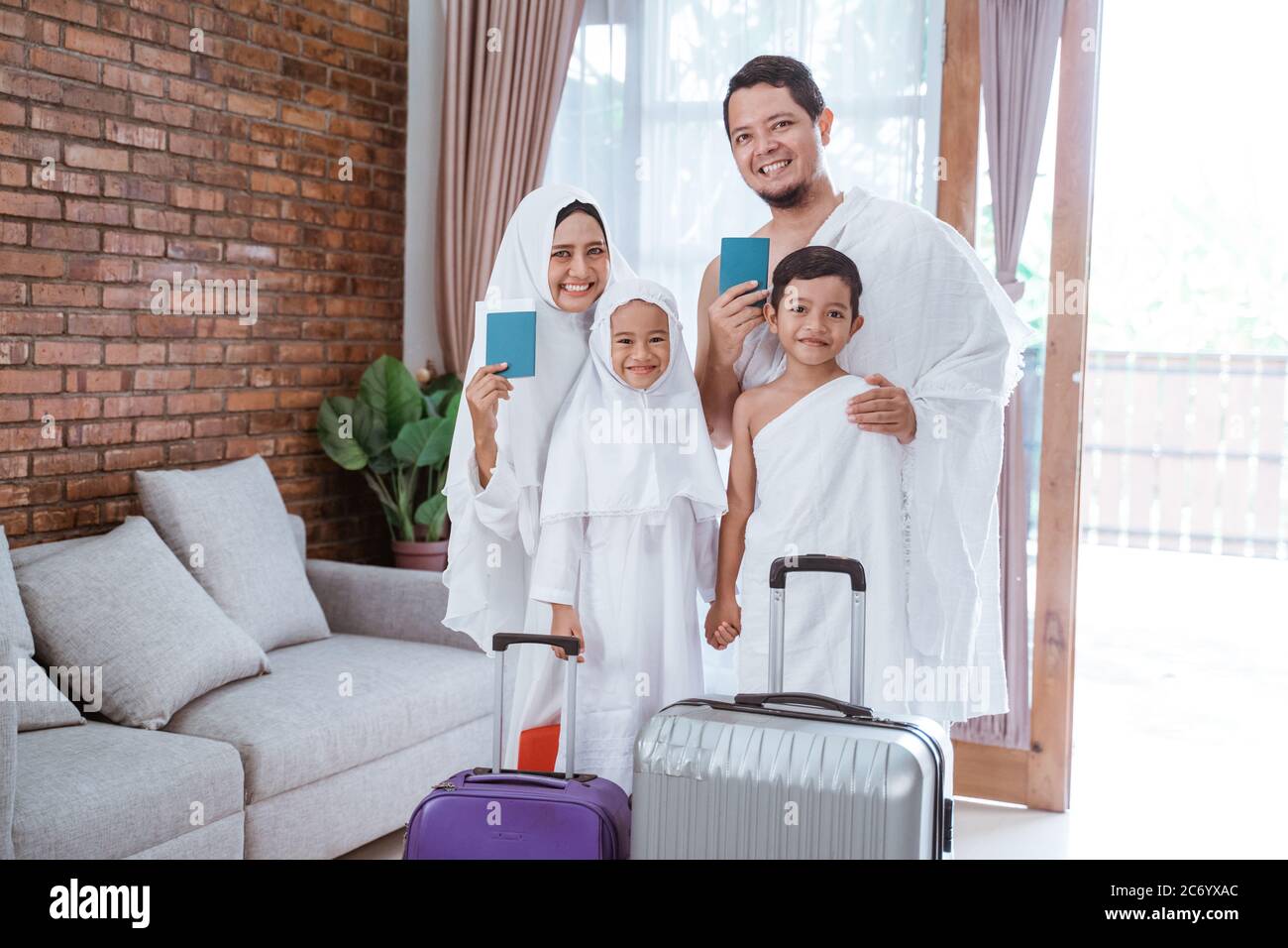 umrah y hayy musulmanes con familia mostrando pasaporte Foto de stock