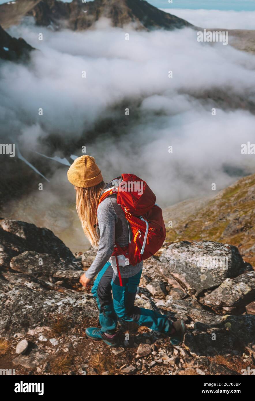 Mujer senderismo en las montañas con mochila roja viaje pista de carrera actividad vacaciones de verano estilo de vida saludable aventura al aire libre solo trekking en Noruega Foto de stock