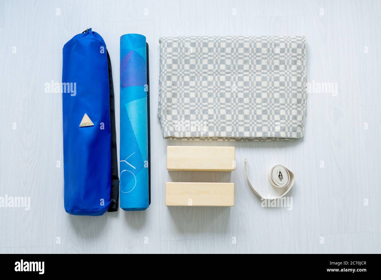 Plano de equipo de yoga. Alfombra azul, bloques, manta de yoga y cinturón sobre fondo claro Fotografía de stock Alamy