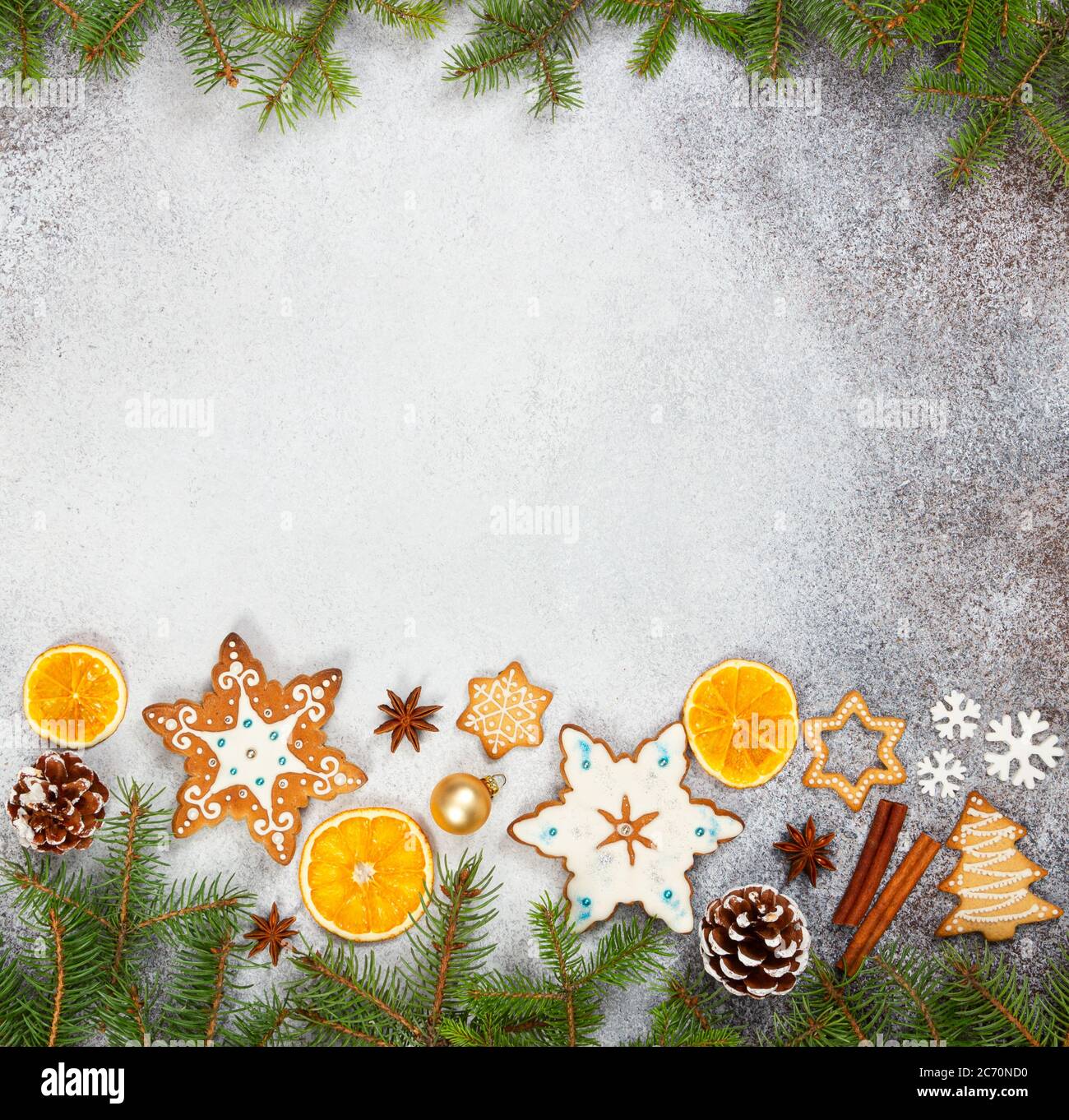 Galletas de jengibre de Navidad en forma de copos de nieve, naranja seco, anís estrellado y conos de abeto sobre fondo de piedra gris. Vista superior. Símbolos de año Nuevo y C Foto de stock