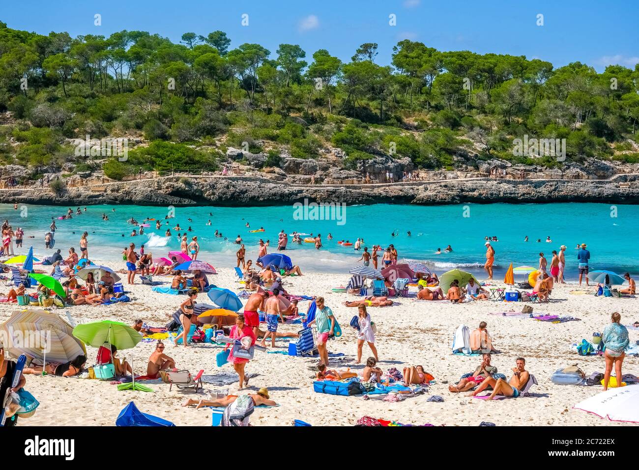 Playa solitaria en el Parc Natural de Mondrago y playa S'amador con numerosos bañistas, que suelen mantener la distancia mínima durante la Corona pandemi Foto de stock