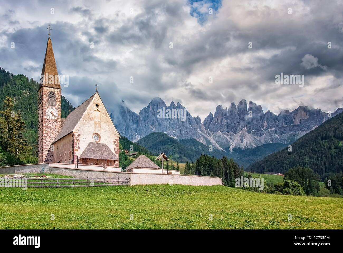 Santa Maddalena pueblo con hermosas montañas Dolomitas en el fondo, valle Val di Funes, Italia Foto de stock