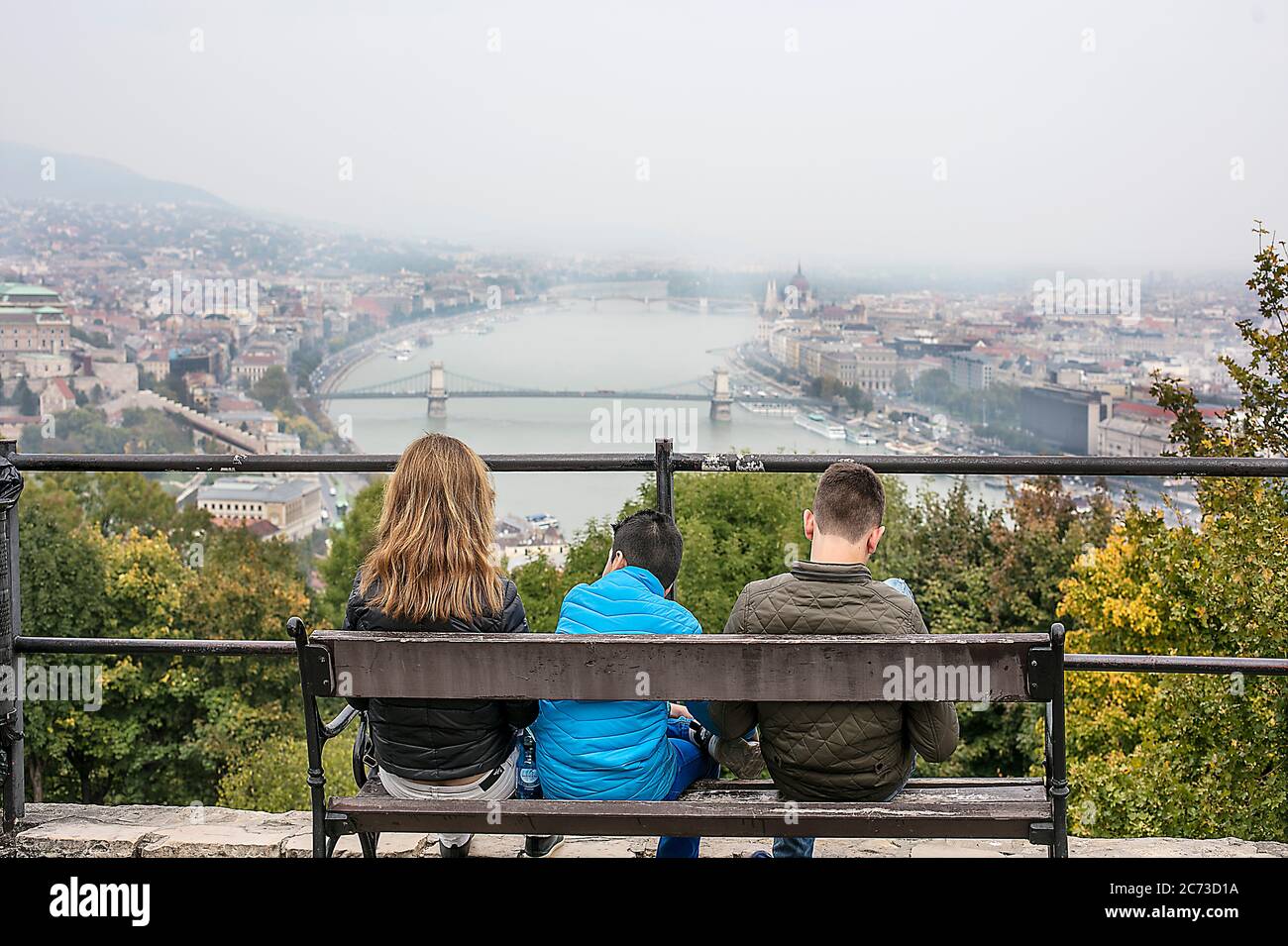 Adolescentes en un banco con vistas al río Danubio en Budapest, Hungría Foto de stock