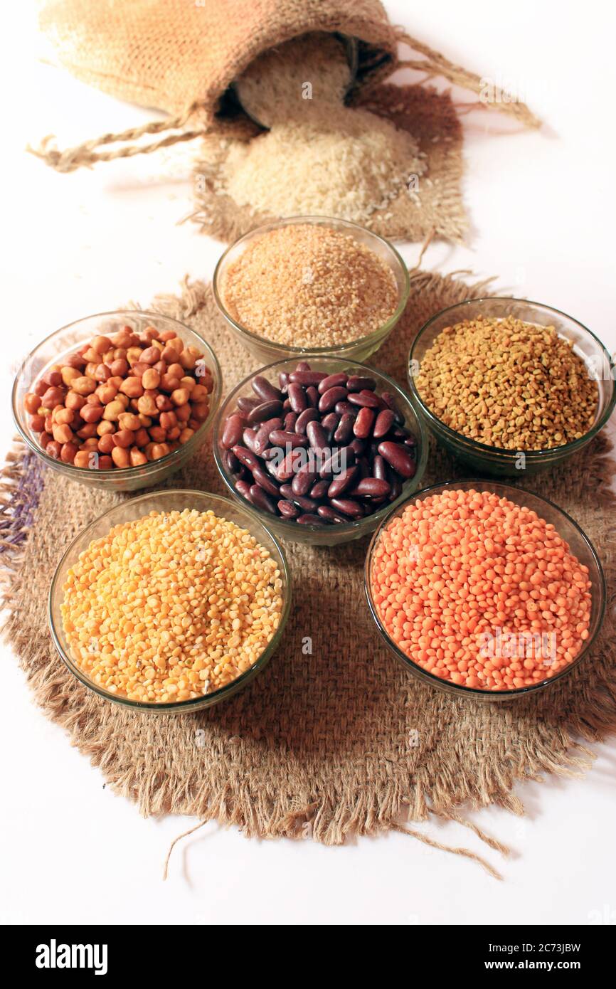 Arroz de un saco pequeño aislado sobre fondo blanco. Diferentes colores en los recipientes. Pechugas, riñón rojo, lentil, semilla de fenogrek, Dalia de trigo, Foto de stock
