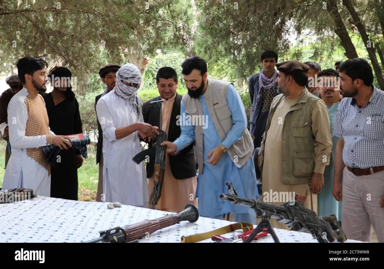 (200714) -- PUL-E-KHUMRI, 14 de julio de 2020 (Xinhua) -- un militante talibán entrega su arma a un funcionario local durante una ceremonia de entrega en Pul-e-Khumri, provincia de Baghlan, Afganistán, 13 de julio de 2020. Doce militantes talibanes se rindieron el lunes en la provincia norteña de Baghlan, en Afganistán, mientras el gobierno ha estado tratando de reconciliar a los insurgentes después de 19 años de insurgencia, dijo una fuente local. (Foto de Sahel/Xinhua) Foto de stock