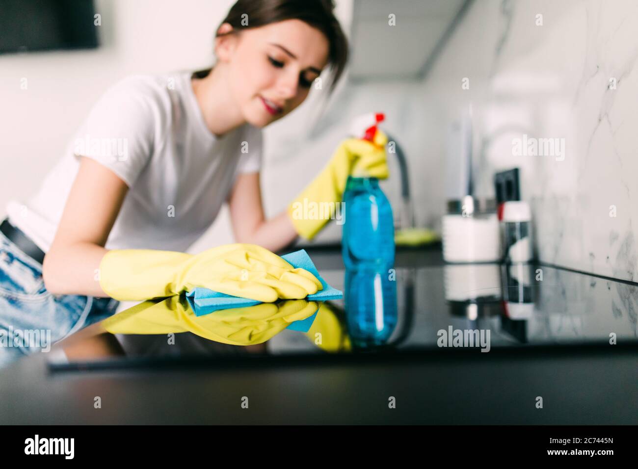 concepto de gente, trabajo de casa y limpieza - mujer feliz limpiando mesa  en la cocina de casa Fotografía de stock - Alamy