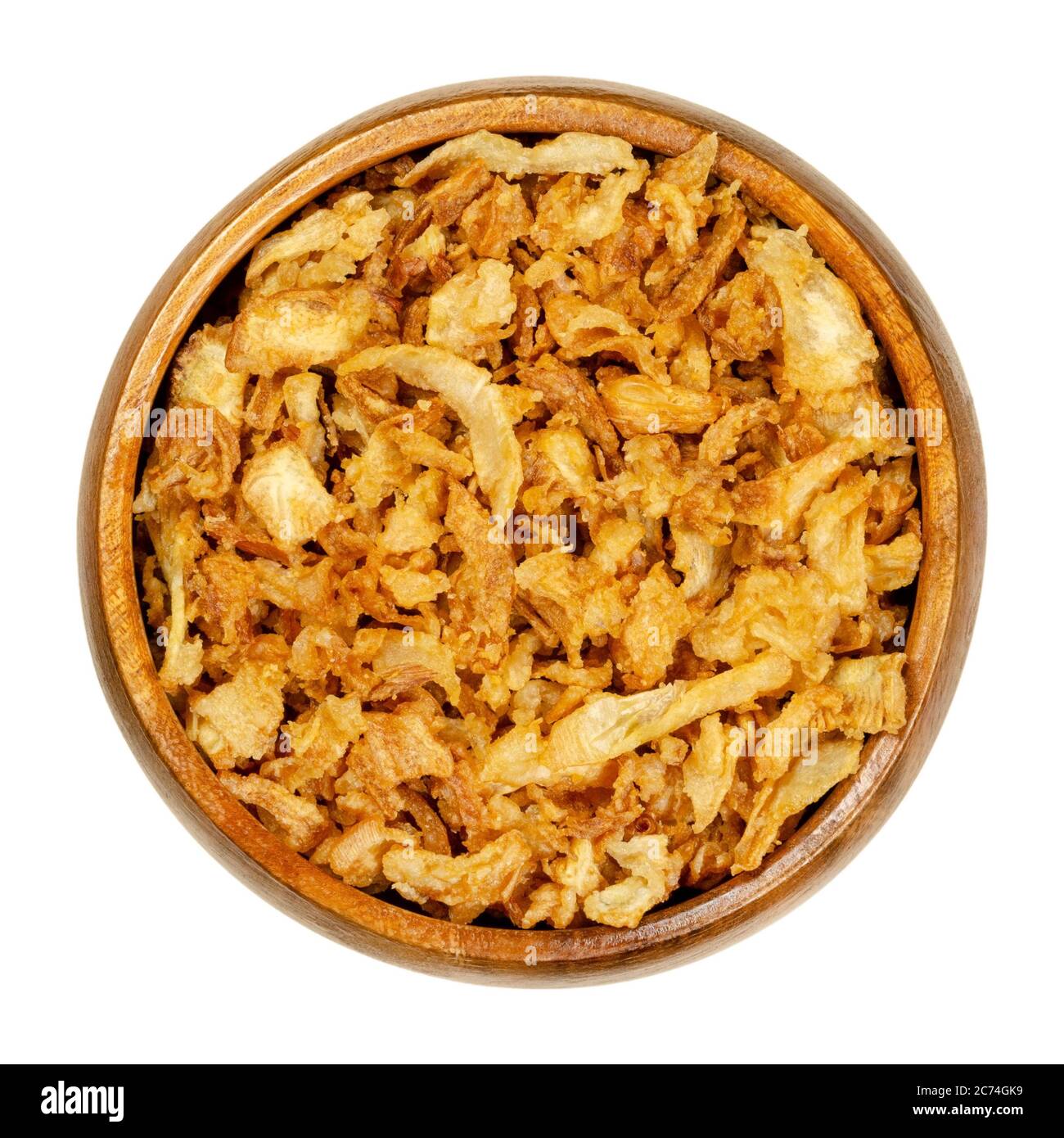 Cebollas fritas en un tazón de madera. Rebanadas fritas de cebolla, usadas como guarnición, también en hamburguesas o para decorar biryani. Primer plano, desde arriba. Foto de stock