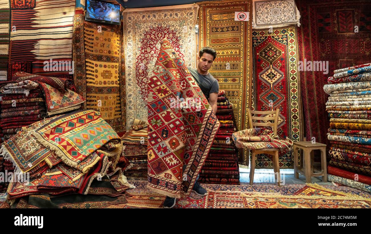 Isfihan, Irán - Mayo 2019: Joven vendedor de alfombras iraní presentando  alfombras persas a los turistas en una tienda de alfombras Fotografía de  stock - Alamy