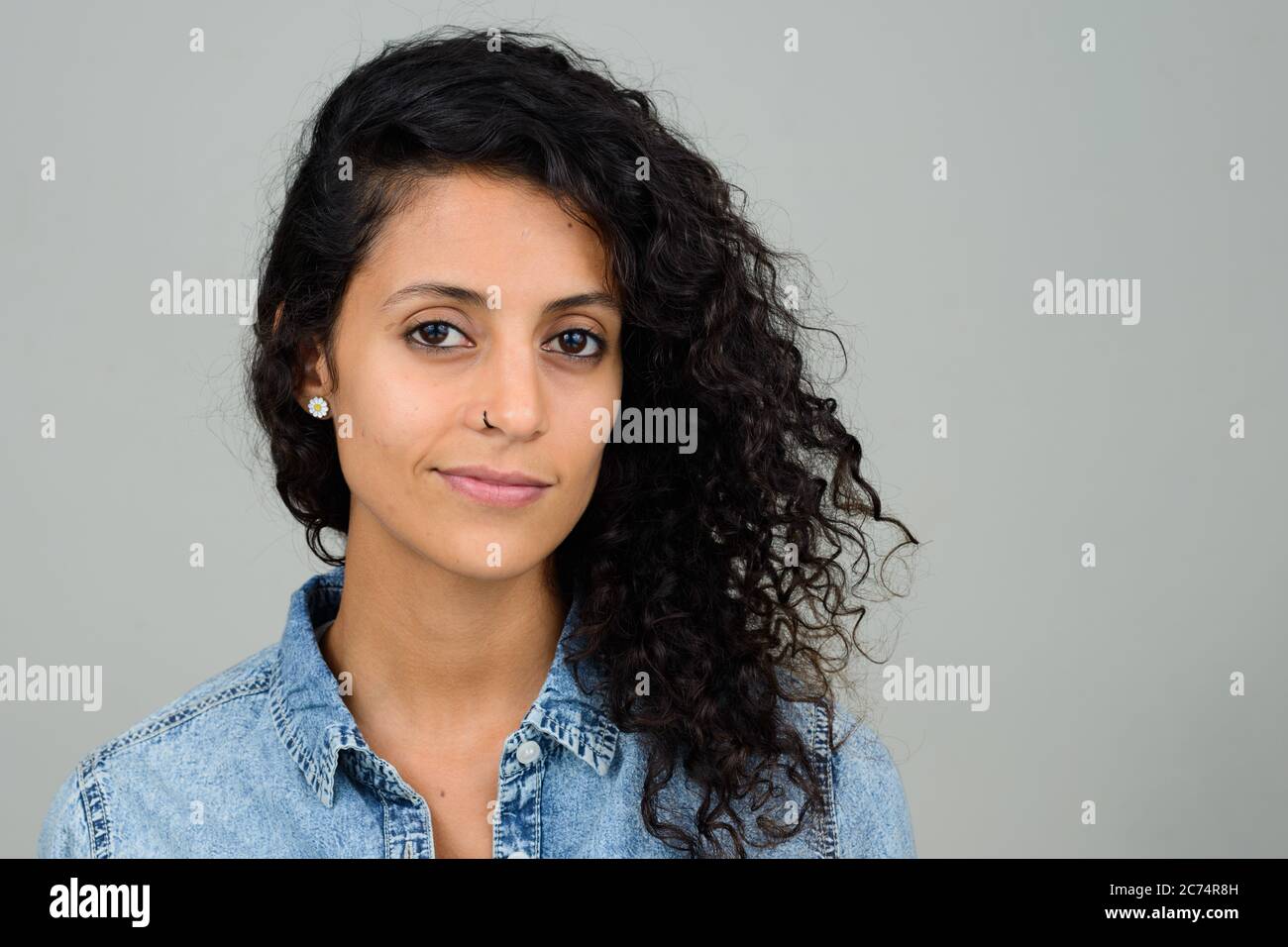 Retrato de una joven hermosa mujer hispana con cabello rizado Foto de stock