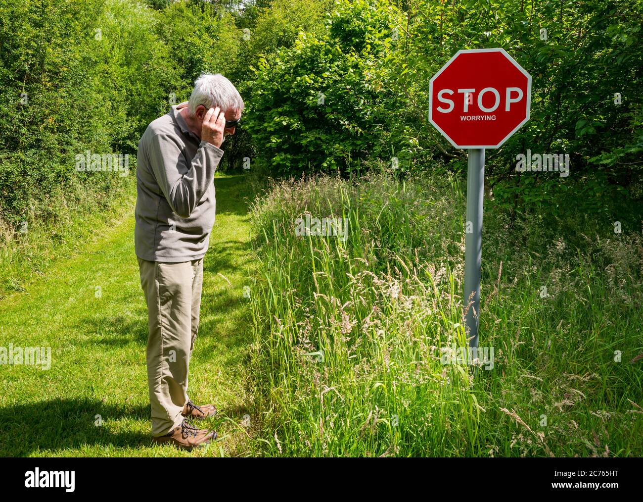 Peculiar señal de advertencia de dejar de preocuparse en el camino del país con el hombre mayor mirando preocupado, Gifford, East Lothian, Escocia, Reino Unido Foto de stock