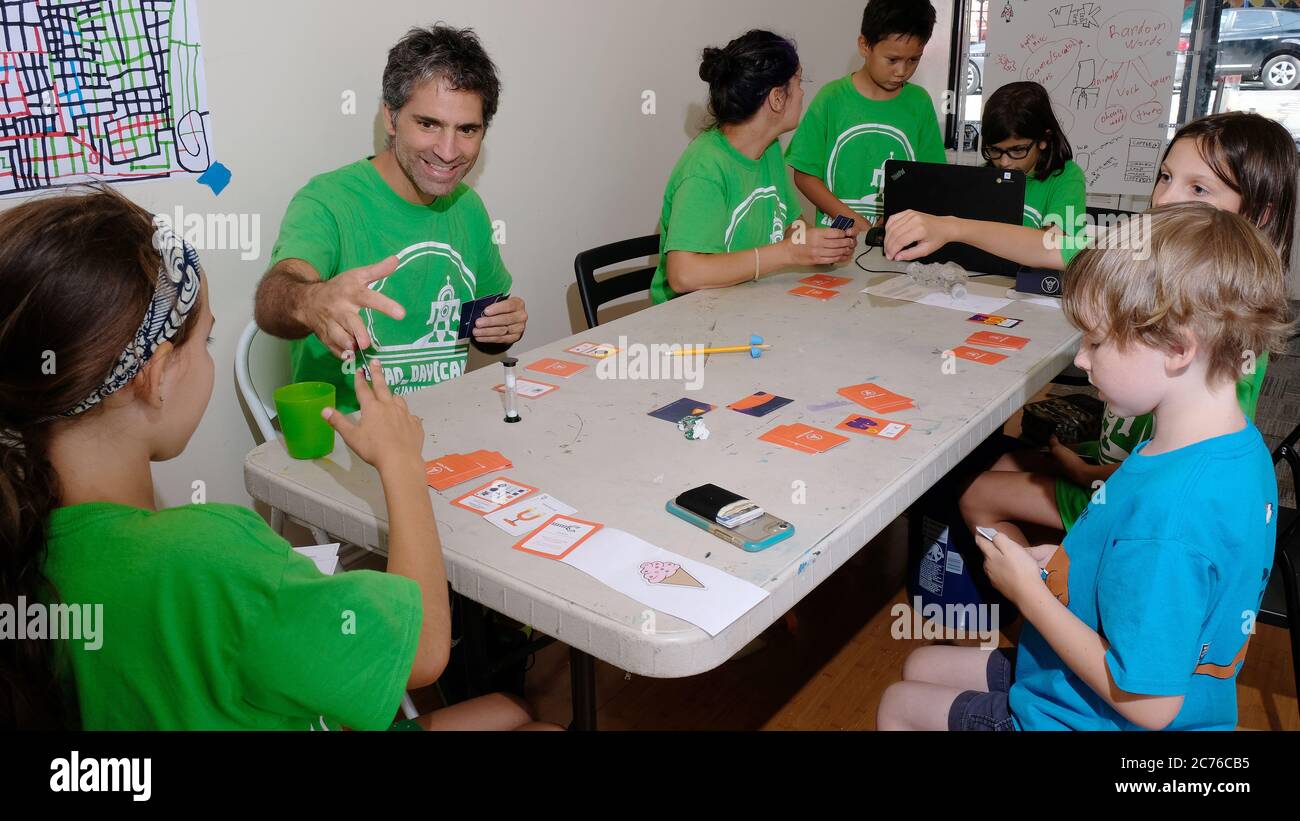 Campamento de día cero. Brooklyn, Nueva York. Niños planeando juego de cartas con instructores Foto de stock