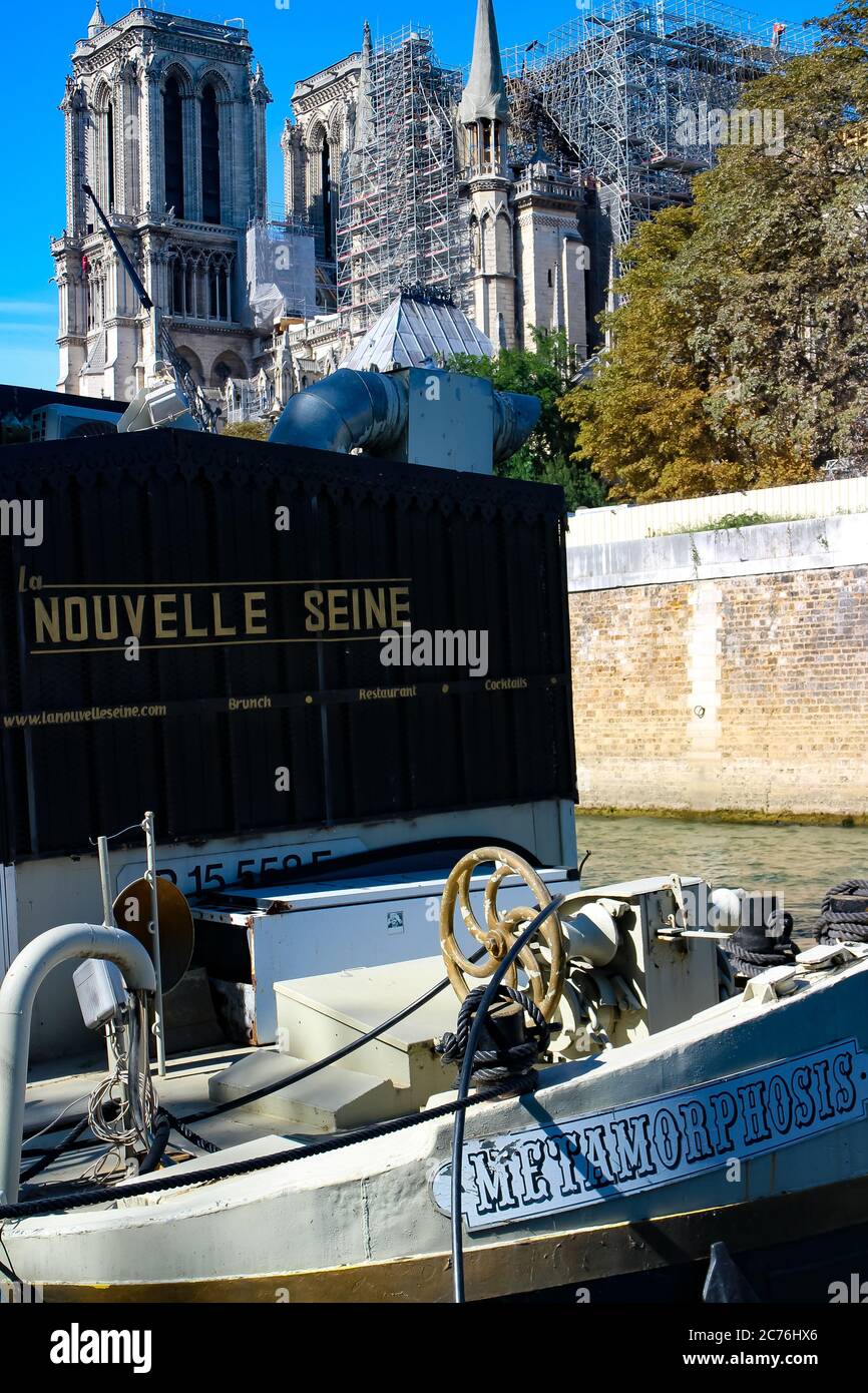 Un barco en el río Sena frente al sitio de restauración de daños por incendio de Notre Dame dice 'Novelle Seine' ('Nuevo Sena') y 'la metamorfosis'. Foto de stock