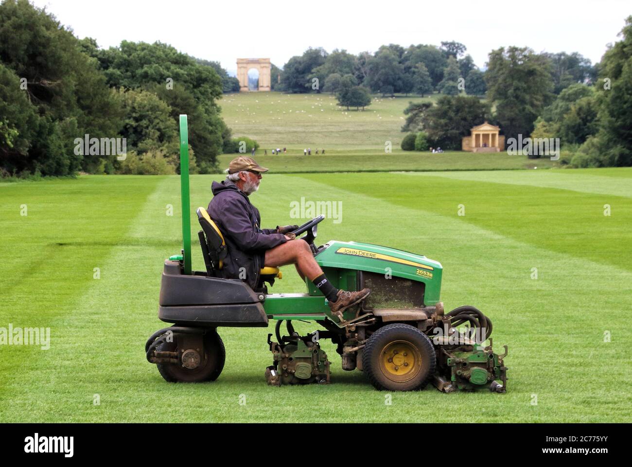 Hombre en el propio cortacésped de paseo tiende el césped en Stowe Landscape Gardens, Stowe House, Buckinghamshire, Inglaterra, Reino Unido el martes 14 de julio de 2020 Foto de stock