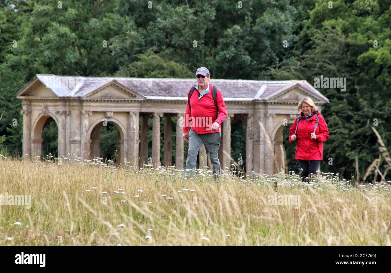 Los visitantes caminan por los campos en Stowe Landscape Gardens, Stowe House, Buckinghamshire, Inglaterra, Reino Unido el martes 14 de julio de 2020 Foto de stock