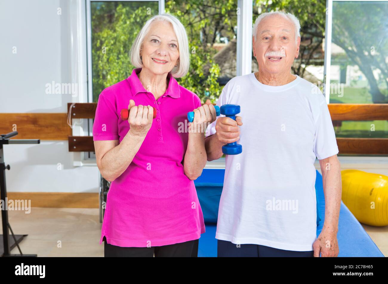 Las personas mayores en el gimnasio haciendo ejercicios físicos. Foto de stock