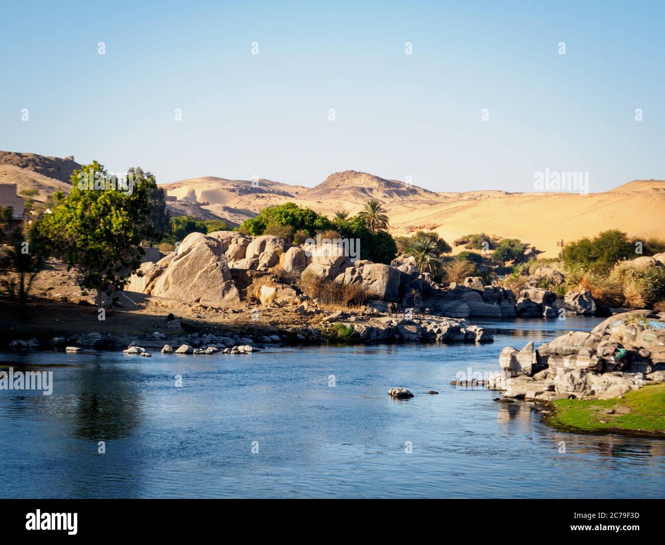 el río nilo se encuentra con el sahara y formaciones rocosas para formar un paisaje espectacular cerca de asuán Foto de stock