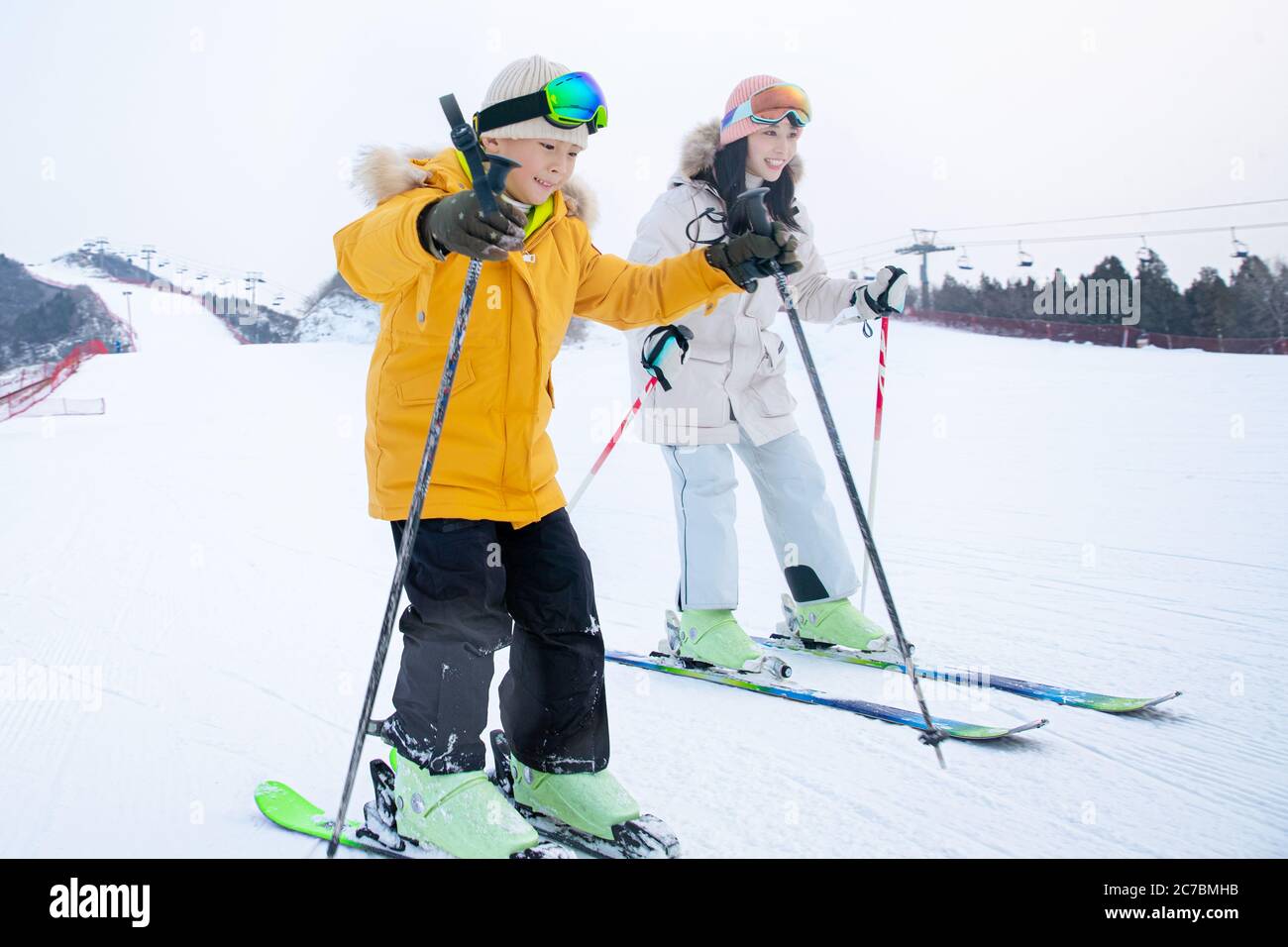 Feliz madre e hijo esquiando juntos en la estación de esquí Foto de stock