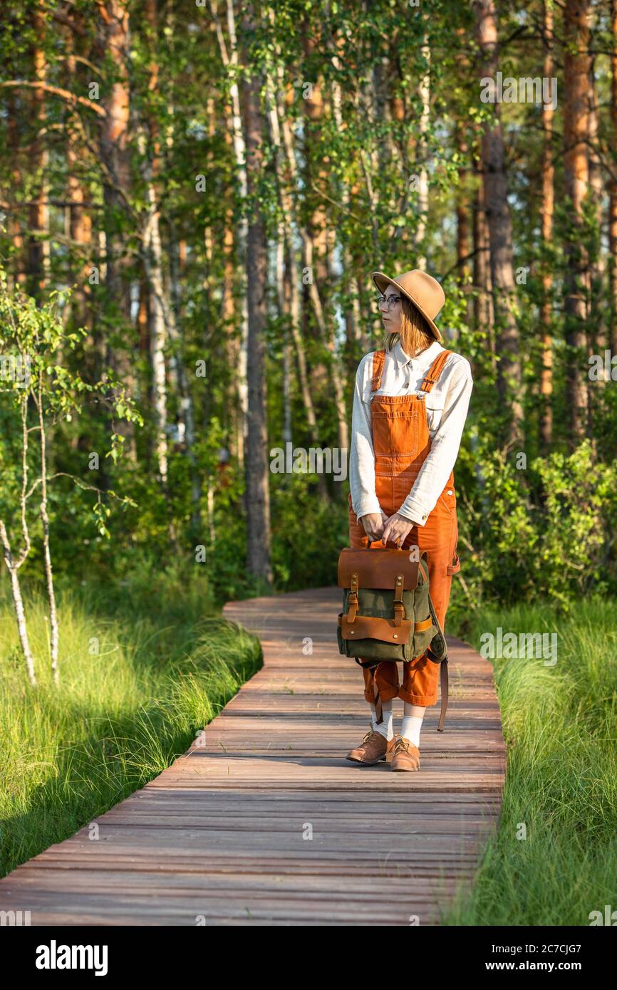 Retrato de mujer botánico con mochila en la ruta ecológica de senderismo en verano. Naturalista explorando la vida silvestre y ecoturismo aventura caminando por el camino Foto de stock