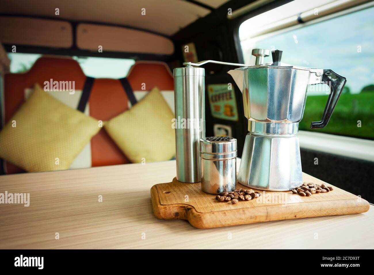 Aqua Bialetti cafetera de topetón, molinillo de café, agitador de chocolate  y granos de café, a punto de preparar café en una bandeja de madera en una  cómoda furgoneta Fotografía de stock -