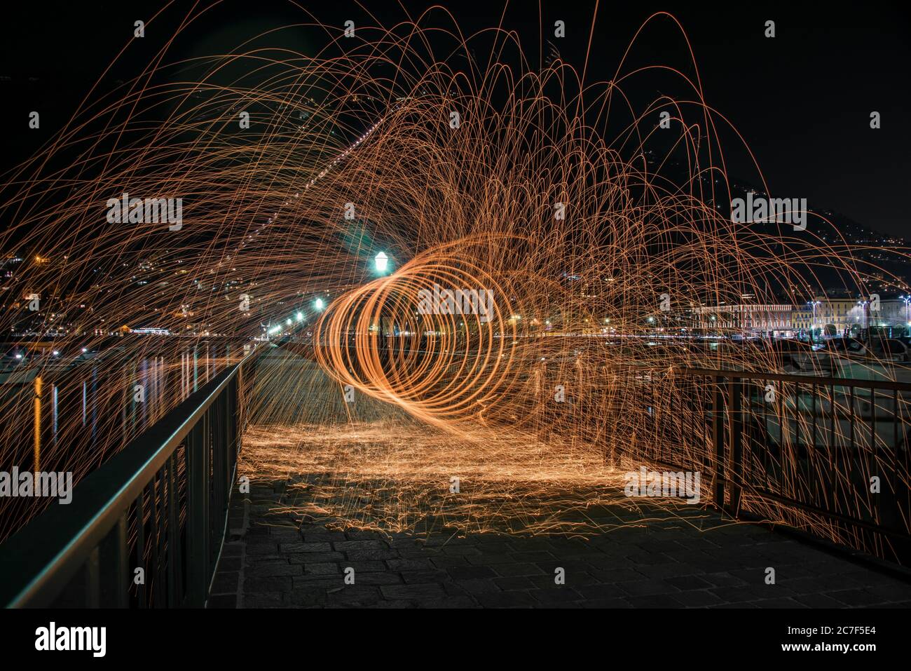 Tiro horizontal de lana de acero efecto en un puente con barandillas de metal en la noche en como, Italia Foto de stock