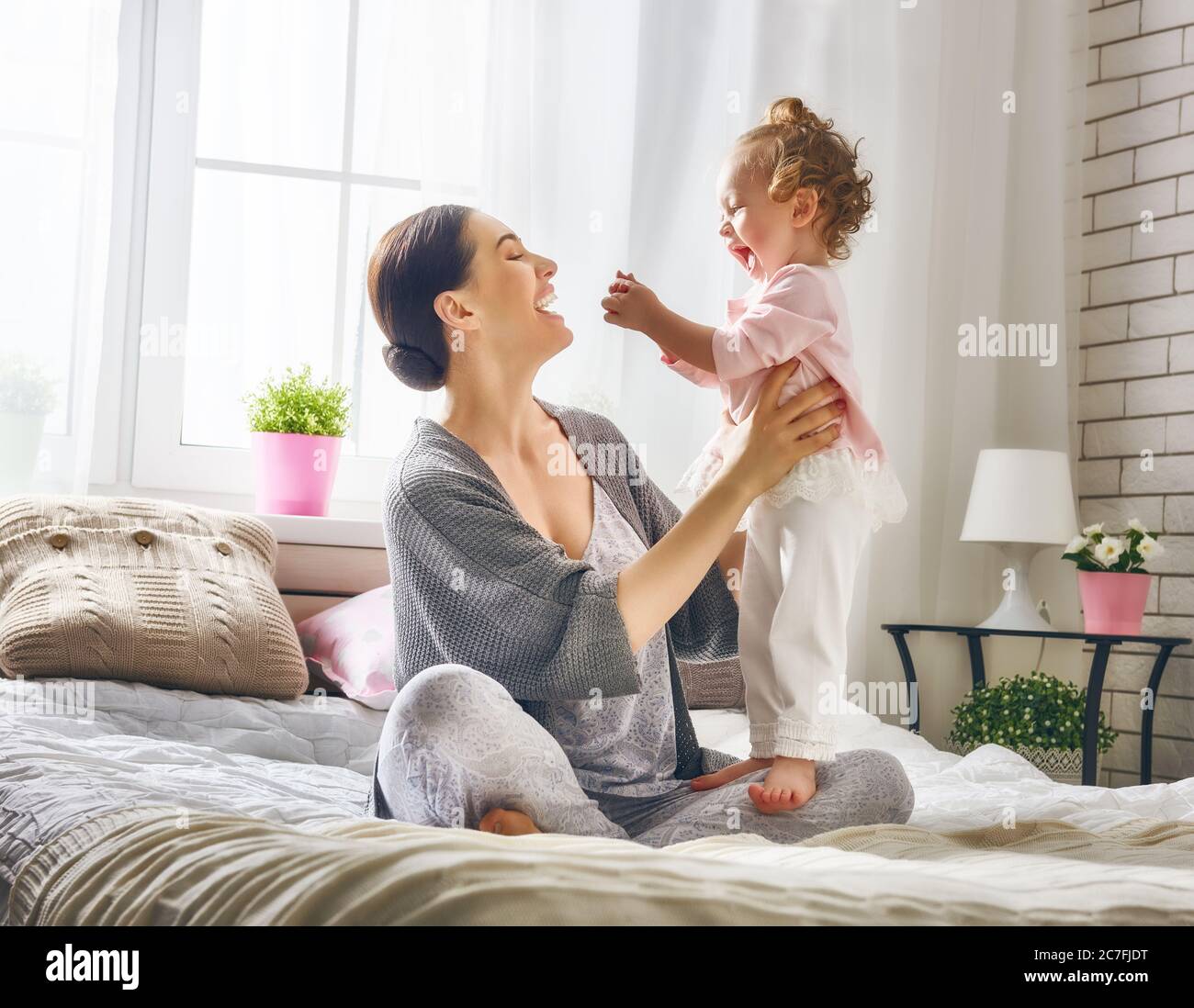 Familia feliz y amorosa. La joven madre está jugando con su bebé en el ...