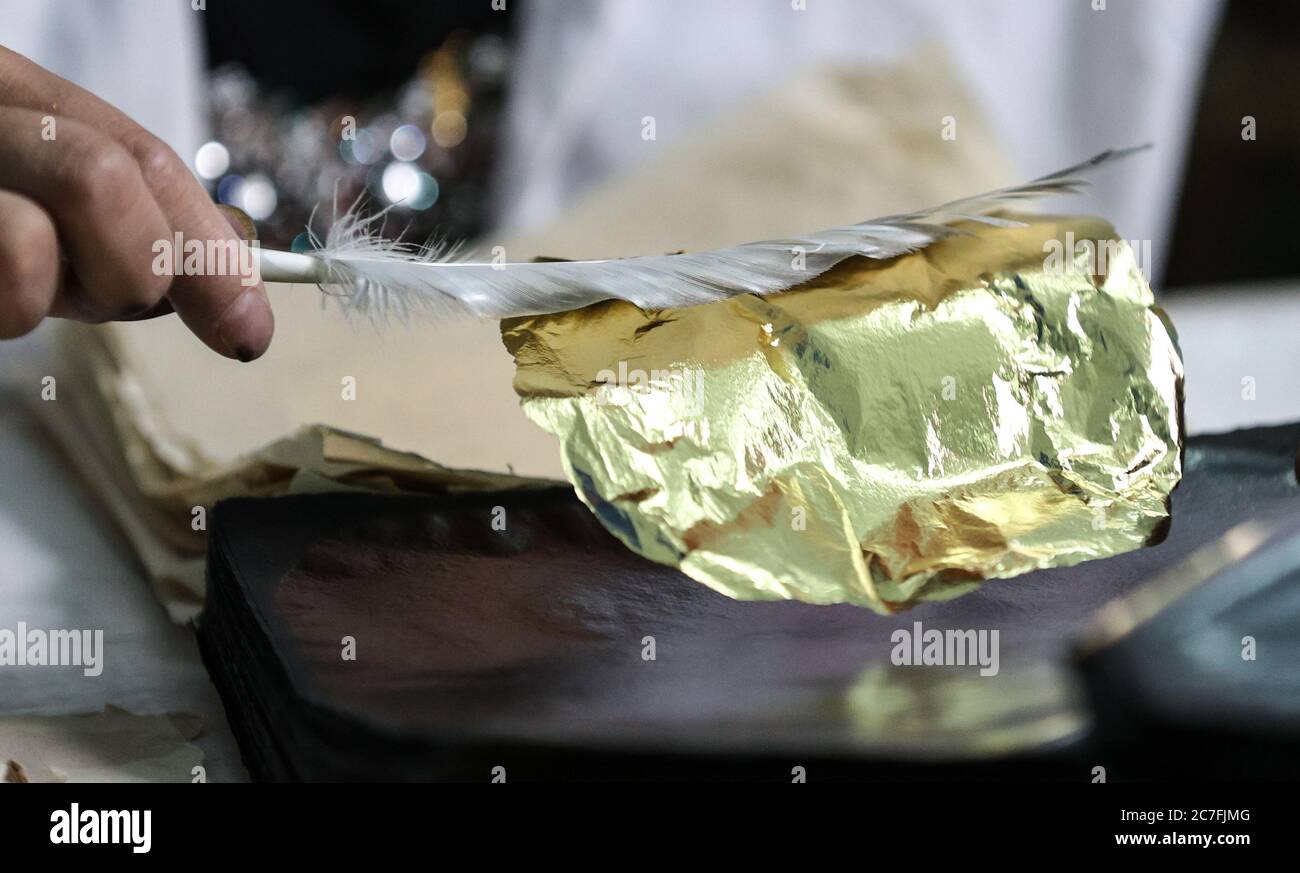 200717) -- NANJING, 17 de julio de 2020 (Xinhua) -- UN artesano usa una  pluma de ganso para mover un pedazo de papel de oro en la fábrica general  de Nanjing Goldthread