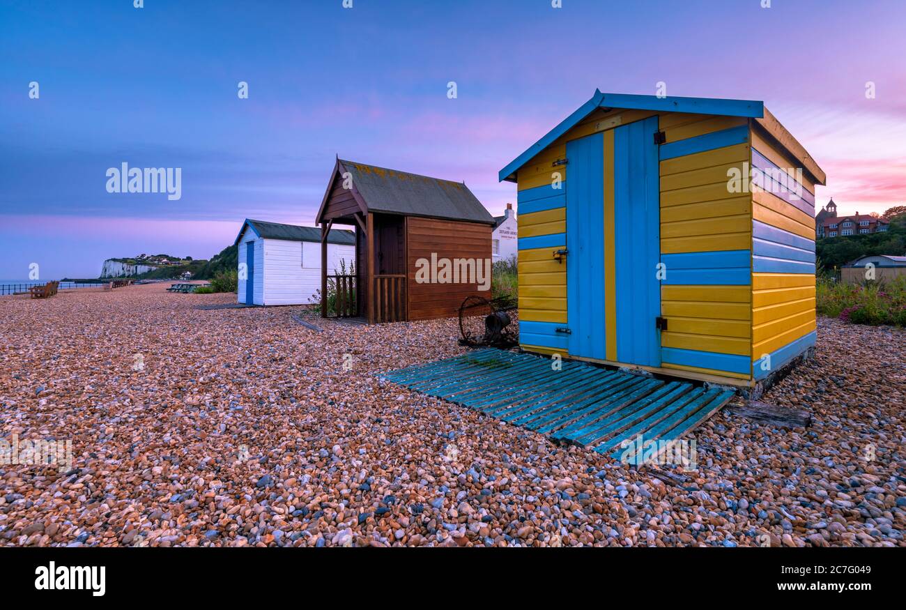 Coloridas cabañas de playa al atardecer en la playa Kingsdown cerca de Deal, Kent. Foto de stock