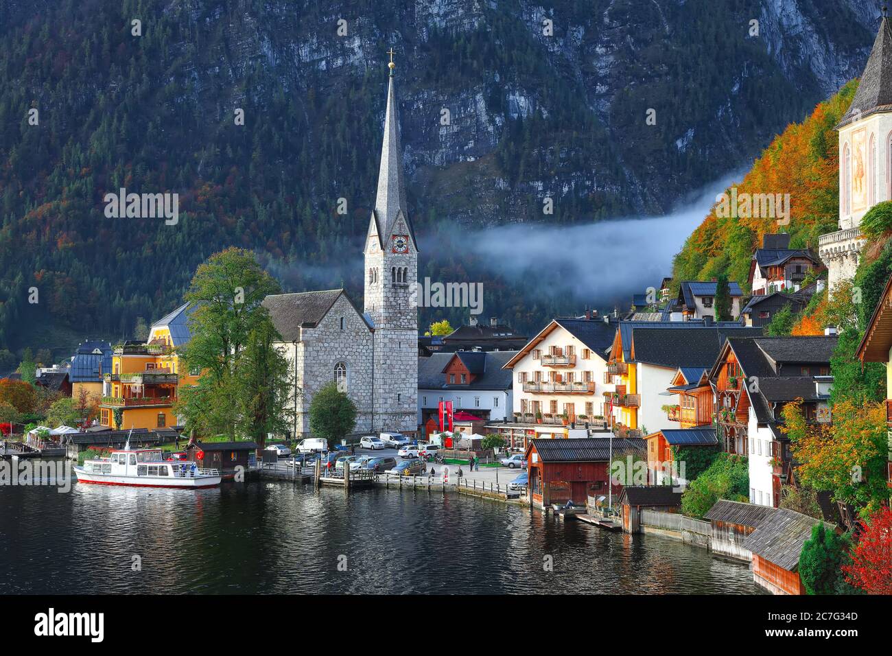 Un amanecer otoñal en la famosa ciudad de Hallstatt a orillas del lago que se refleja en el lago Hallstattersee. Ubicación: resort Village Hallstatt, Salzkammergut región, Foto de stock