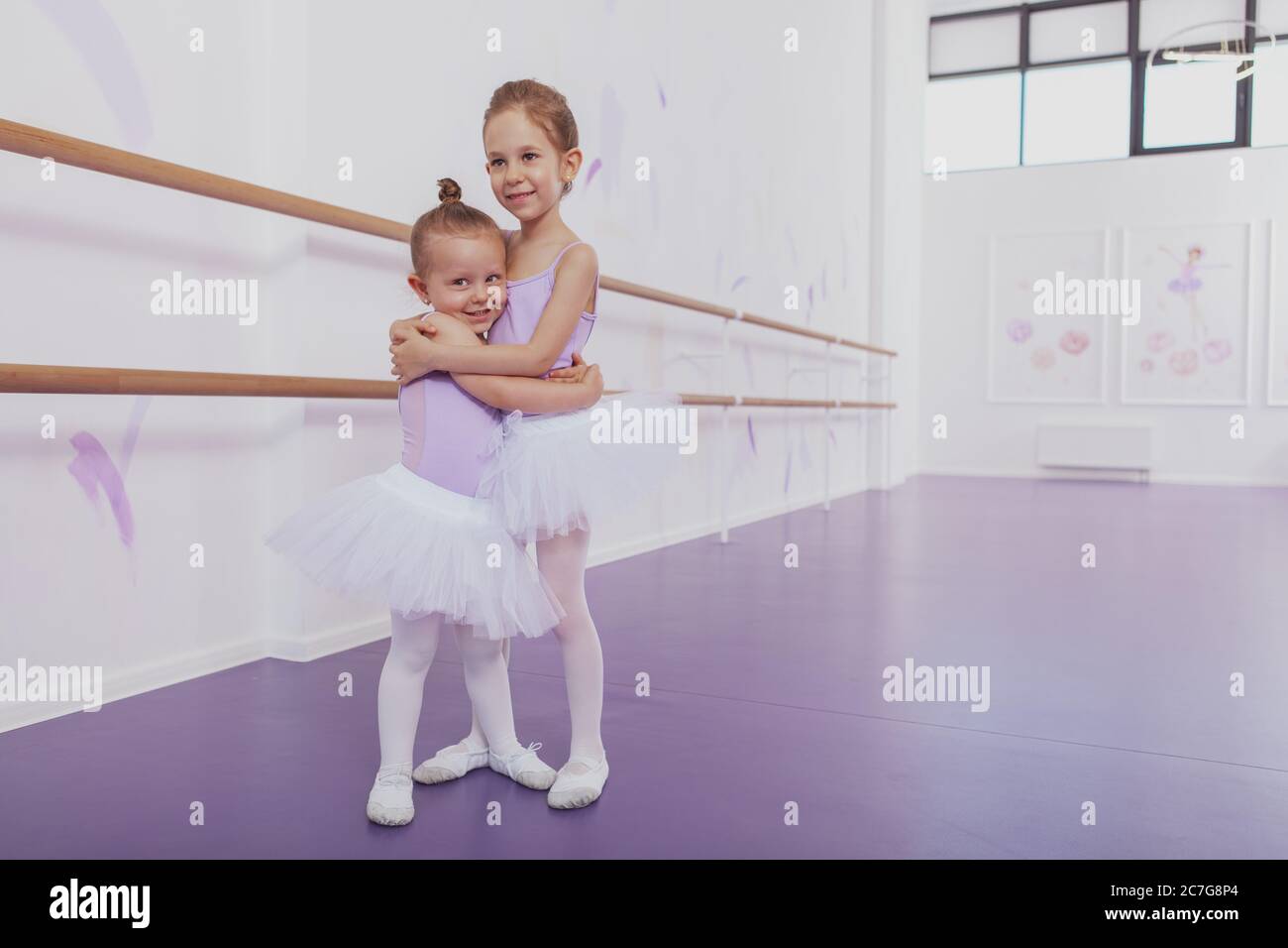 Orgullosa niña afroamericana en ballet vistiendo una falda de tutú rosa  niños de pie en ballet