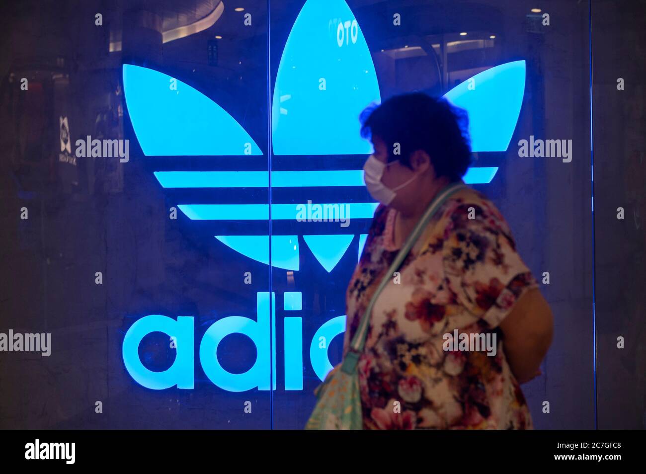 29 de mayo de 2020, Hong Kong, China: Un comprador que lleva una máscara de  cara pasa por delante de una Marca multinacional alemana de ropa deportiva  Adidas logo en un centro