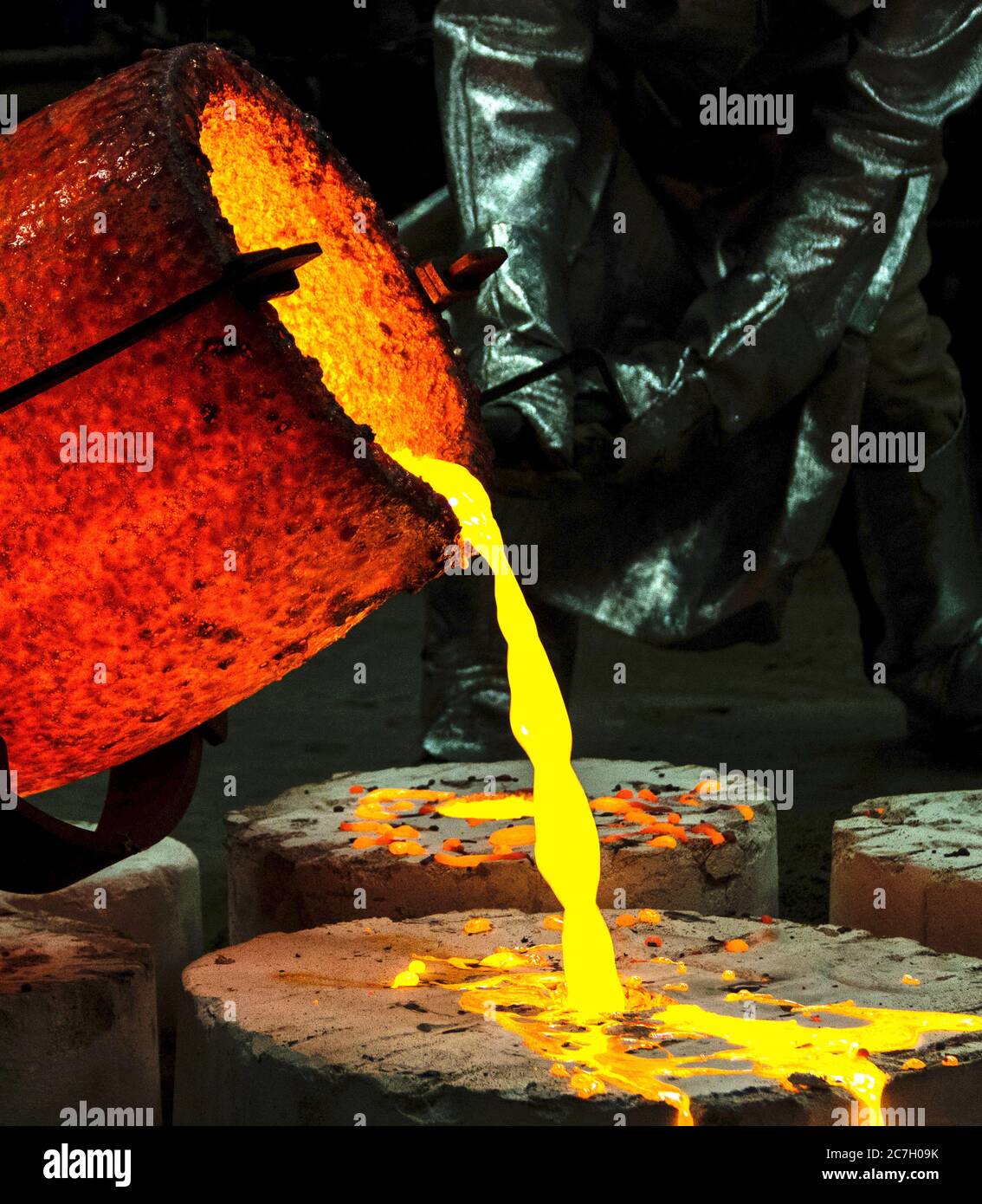 trabajador en una sala de protección que abrasaba el metal líquido en una fábrica de fundición Foto de stock